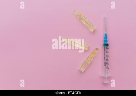 Beauty Injection, facial skin lifting on pink background concept.Glass Medicine Vials ampule ,medicine pill and capsule isolated. concept of cosmetic injections.Copy space Stock Photo