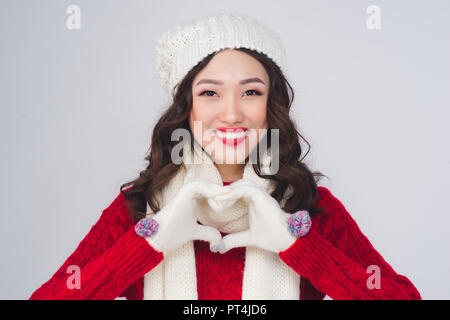 Beautiful smiling fashion model face with red lips in warm clothing gesture heart shape Stock Photo