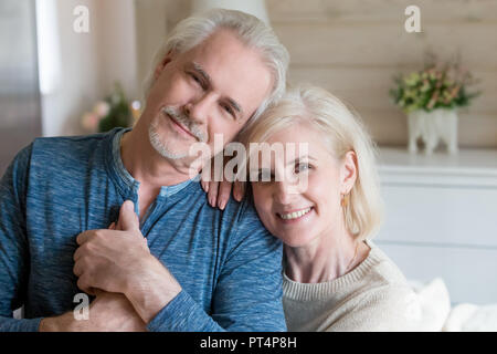 Happy affectionate mature man and woman embracing looking at cam Stock Photo