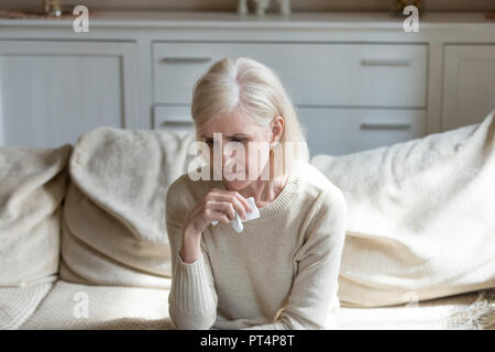 Sad lonely middle aged woman crying holding handkerchief, grievi Stock Photo