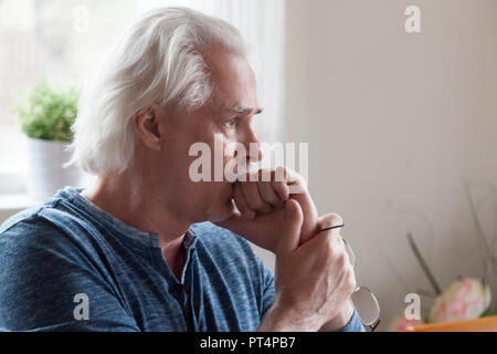 Worried serious senior man looking away feeling anxious about pr Stock Photo