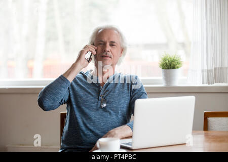 Senior mature man talking on phone making call at home Stock Photo