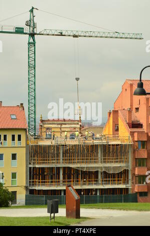 Bricklayers, Carpenters And Crane Operators Performing Their Work In A Construction Site. Architecture, Works And Services, Crafts, Portrait. July 31, Stock Photo