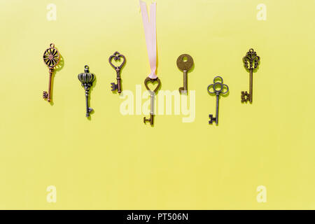 Bunch of keys, steel house keys on yellow background.a lot of different keys isolated.Valentines unlock love concept.Copy space Stock Photo