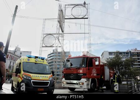 October 5, 2018 - Athens, Greece - An ambulance, vehicle of the fire brigade and police seen during the rescue of a man from the top of a metal sculpture..A man climbed up to a metal sculpture and threatened to commit suicide in Omonia Square, central Athens. The man was lifted with a crane by firefighters. (Credit Image: © Giorgos Zachos/SOPA Images via ZUMA Wire) Stock Photo