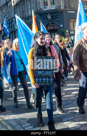 Edinburgh, Scotland, UK. 6th October, 2018. A female campaigner in support of Scottish Independence carrying a sign saying Scotland Welcomes Immigrants. Organised by the group All Under One Banner the march travelled from Johnston Terrace through the city to a rally in Holyrood Park. Credit: Skully/Alamy Live News Stock Photo