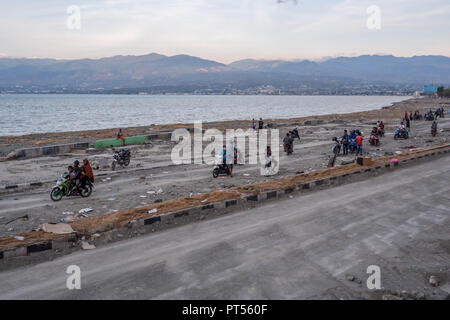 Palu, Indonesia. 4th Oct, 2018. Residents seen crossing the damaged Cumi-cumi road after the earthquake and tsunami.A deadly earthquake measuring 7.7 magnitude and the tsunami wave caused by it has destroyed the city of Palu and much of the area in Central Sulawesi. According to the officials, death toll from devastating quake and tsunami rises to 1,347, around 800 people in hospitals are seriously injured and some 62,000 people have been displaced in 24 camps around the region. Credit: Hariandi Hafid/SOPA Images/ZUMA Wire/Alamy Live News Stock Photo