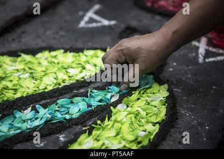 Lima, Peru. 6th Oct, 2018. Devotees making a carpet of flowers, outside the church where the image of the Lord of the Miracles will start the procesion. Every October for the past four centuries this procession takes place in Lima and is known as the most important religious event in Peru. This Peruvian tradition commemorates the devastating 1746 Lima earthquake which left only a mural of Christ standing in a city area. Credit: Guillermo Gutierrez/SOPA Images/ZUMA Wire/Alamy Live News Stock Photo