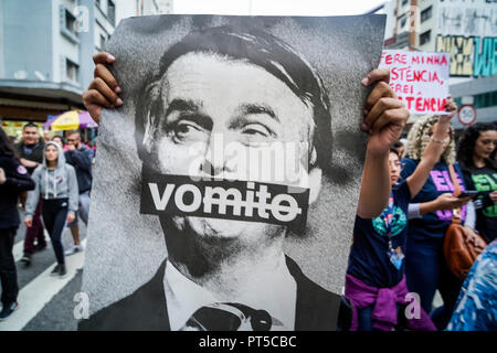 Sao Paulo, Brazil. 06th Oct, 2018. A woman holds up an anti-Bolsonaro poster at a demonstration against the presidential candidacy of far-right politician of Jair Bolsonaro on October 6, 2018. The sign translates as 'vomit'. (Credit: Pablo Albarenga/dpa) Credit: Pablo Albarenga/dpa/Alamy Live News Stock Photo