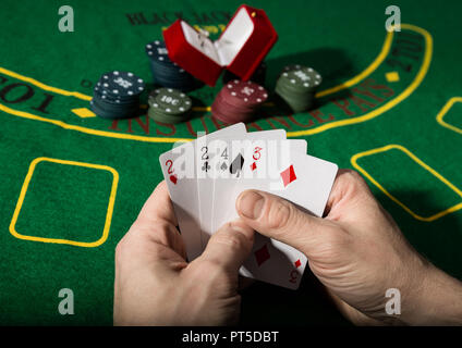 Winning combination in poker game. Cards and chips on a green cloth. Stock Photo