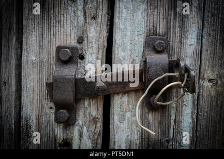 Rusty door bolt on grey wooden door Stock Photo