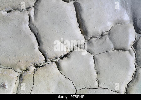 Light gray dry cracked surface of volcanic earth turned into desert. Detailed natural background, texture taken in environment in crater of active vol Stock Photo
