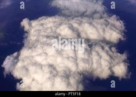 White cumulus clouds on the dark background of the earth in the early evening, view from above Stock Photo