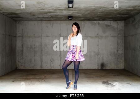 Japanese Girl poses on the street in Nakameguro, Japan. Nakameguro is a town located in the nice area of Tokyo. Stock Photo
