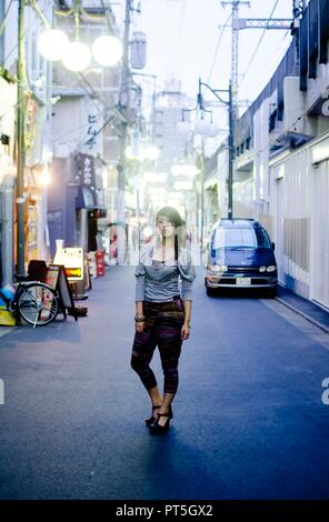 Japanese Girl poses on the street in Nakameguro, Japan. Nakameguro is a town located in the nice area of Tokyo. Stock Photo