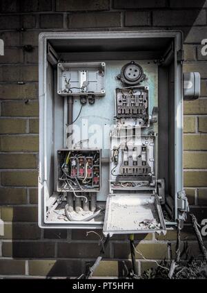 Disused fuse box on wall of abandoned industrial building. Stock Photo
