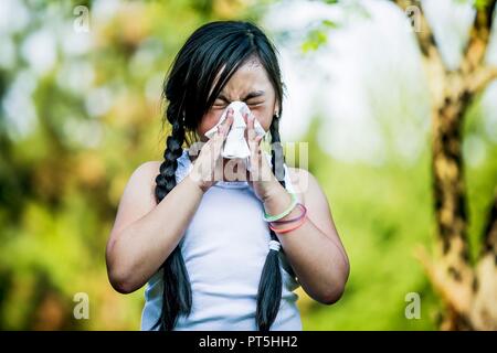 Girl using handkerchief while sneezing. Stock Photo