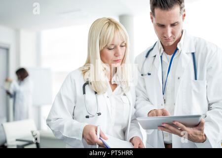 Male and female doctors inspecting digital tablet. Stock Photo