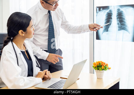 Professional doctors discussion about x-ray result in medical office hospital Stock Photo