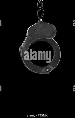 steel handcuffs of police special equipment, fetters on a black background Stock Photo