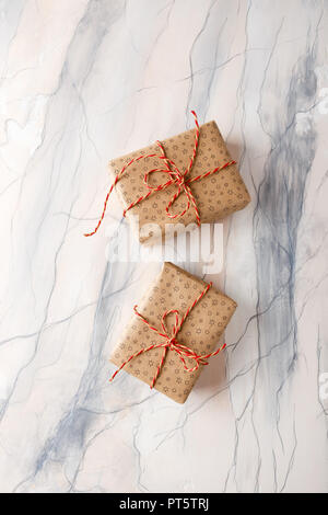 Two gift boxes packed in craft paper on a background of pink marble Stock Photo