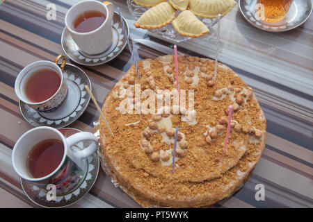 Hazelnut milk cake . Delicious cakes with hazelnut on wooden glass table . Black tea in glass cup on the table . Azerbaijan tea in traditional glass on tray closeup Stock Photo