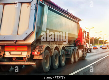 dump truck goes in the evening on highway Stock Photo