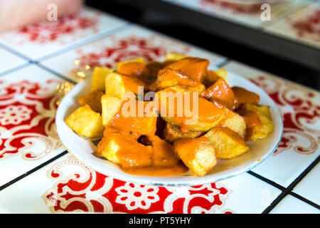 Traditional Spanish tapas dish Patatas Bravas in sauce served at a restaurant, Barcelona, Spain Stock Photo
