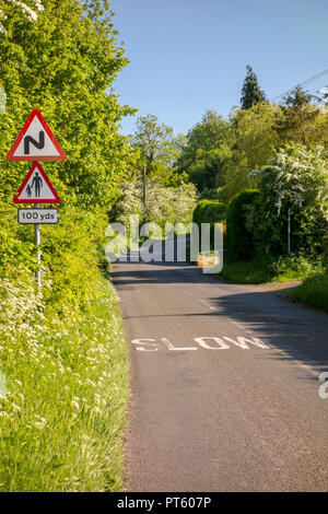 Warning triangle road signs for bends and pedestrians with slow sign on a British country lane, Sharpenhoe, UK Stock Photo