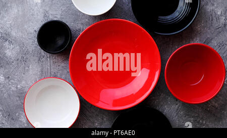 Collection of empty colorful decorative ceramic bowls on grey stone background. Stock Photo