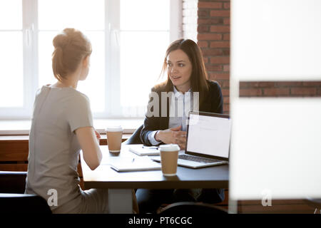 Friendly young businesswomen talking chatting in office during c Stock Photo