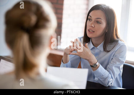 Confident focused businesswoman speaking to people at business n Stock Photo