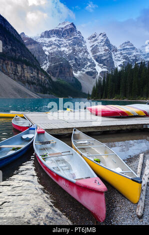 Colorful canoes docked at Moraine Lake in Banff National Park, Canada Stock Photo
