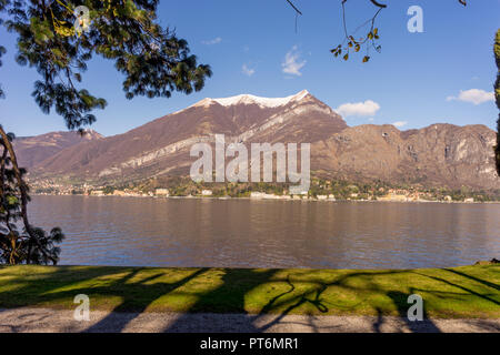 Italy, Bellagio, Lake Como, SCENIC VIEW OF SNOWCAPPED MOUNTAINS AGAINST BLUE SKY with swans on lake Stock Photo