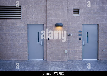 Industrial facility with secure doors, vents and security light. Stock Photo