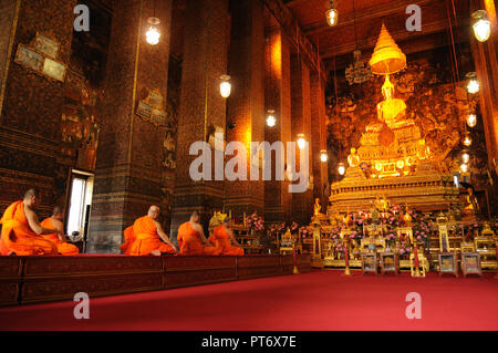 Buddhist monks sit on the knees inside Wat Pho Temple, in Bangko Stock Photo