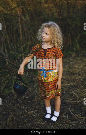 little curly blonde girl holding a vintage lantern Stock Photo