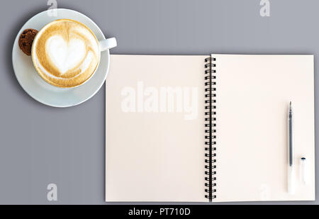 top view of open spral note pad and cup of cappuccino  Stock Photo