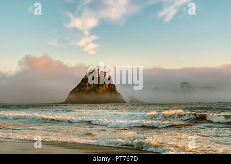 Beautiful sunset over Rialto Beach with sea stacks caught in the clouds or mist or fog, Pacific Coast, Olympic National Park, Washington state, USA. Stock Photo