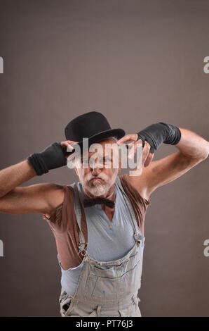 Old dirty beggar is angry, making scary face Stock Photo