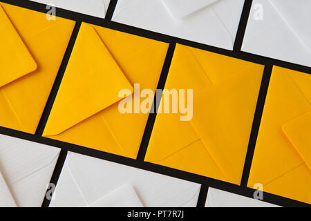Composition with white and yellow, envelopes on the table. Different colored envelopes on the table. Stock Photo