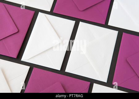 Composition with white and purple envelopes on the table. Different colored envelopes on the table. Stock Photo