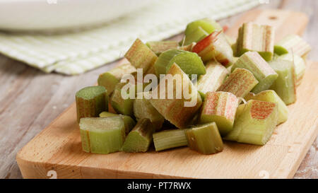 Raw sliced stalks of rhubarb on a cutting board Stock Photo