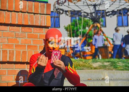 HUSTOPECE, CZECH REPUBLIC - OCTOBER 7, 2018:  Street performer putting on his face make-up. Street performers can fool passersby and entertain tourist Stock Photo