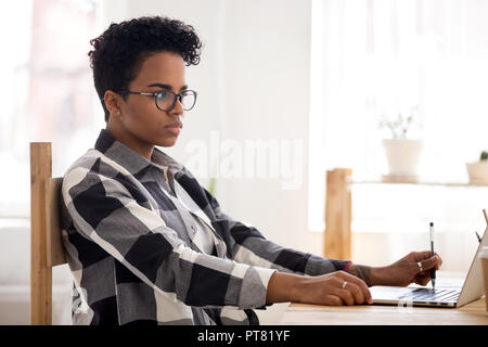 Young African woman working studying in office  Stock Photo