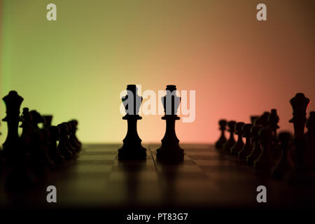 Chess game two kings in centre of board other pieces lined up. In dramatic light. Concept of battle between two forces. Stock Photo