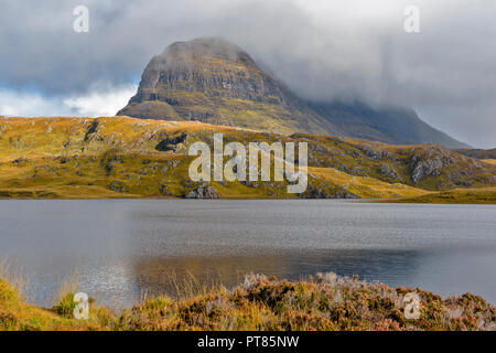 SUILVEN AND RIVER KIRKAIG SUTHERLAND SCOTLAND SUNSHINE ON FIONN LOCH AND MIST AND RAIN CLEARING OVER THE MOUNTAIN Stock Photo