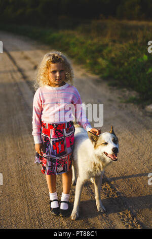 curly blond little girl and big dog Stock Photo