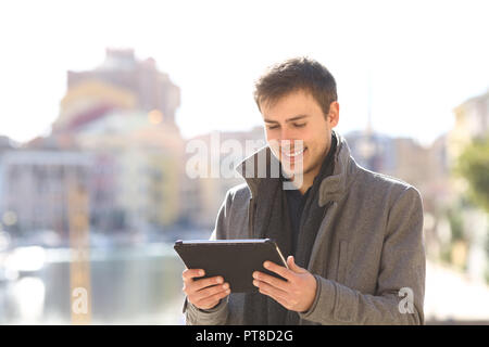 Happy man checking a tablet content in winter holiday Stock Photo