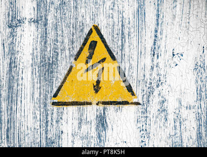 High voltage lightning sign in a yellow triangle on a painted wall. Stock Photo